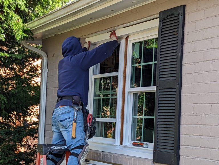 Hallmark installer fitting exterior trim above new Vytex replacement windows at a Columbia home