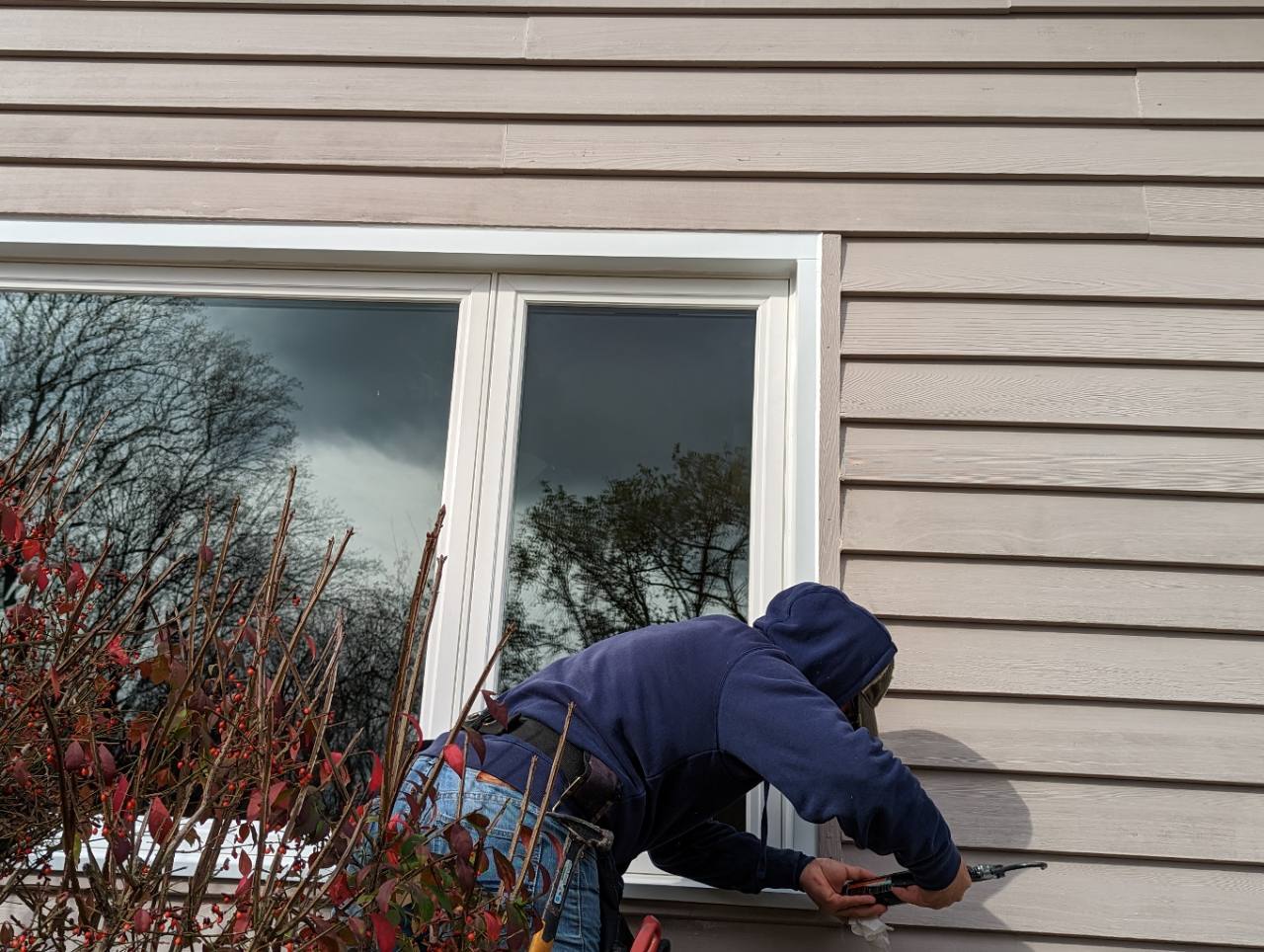 Hallmark installer sealing and finishing a large Vytex replacement window at a Columbia home