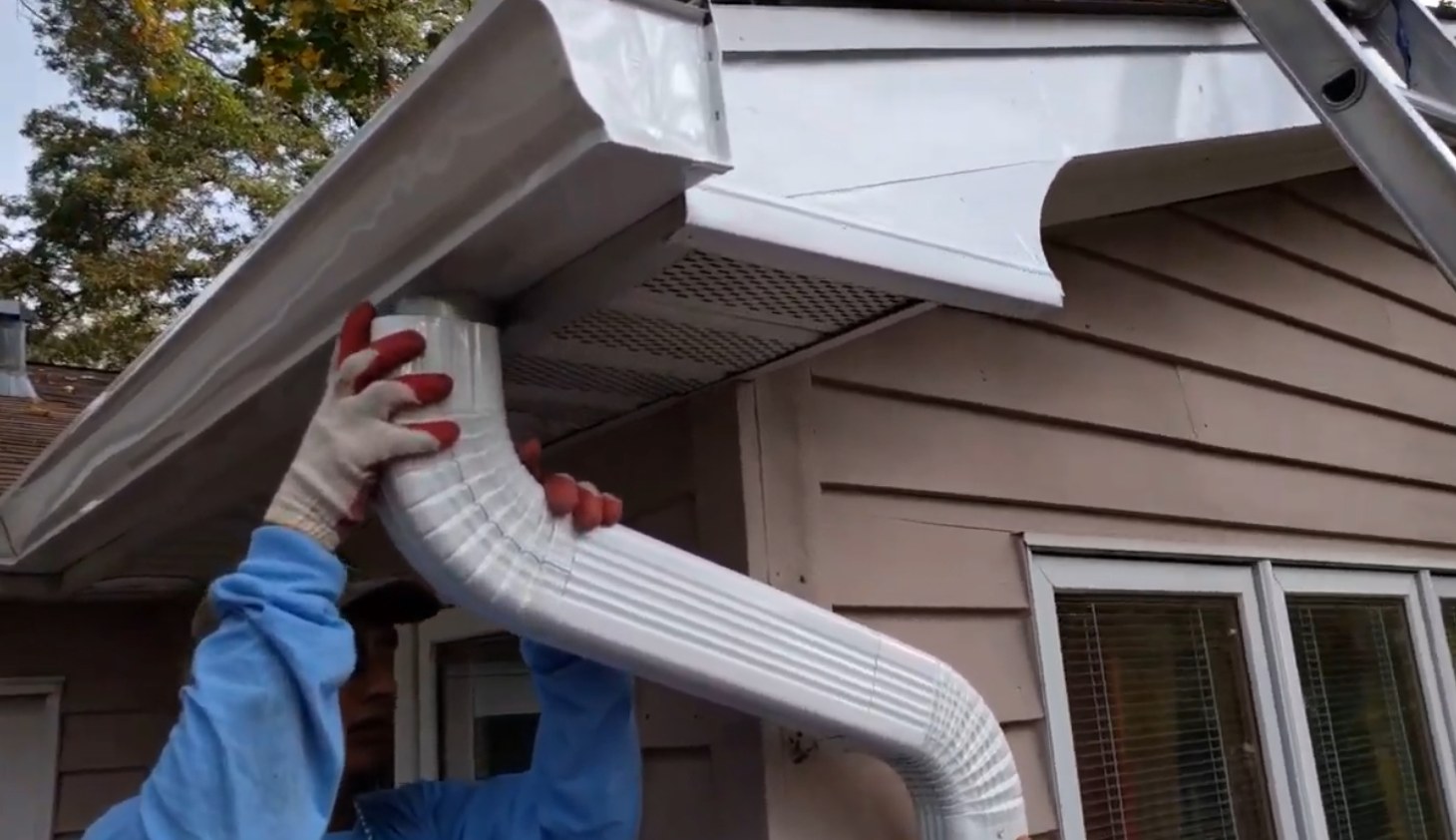 Next Day Gutters crew member installing a white downspout at a Columbia, Maryland home