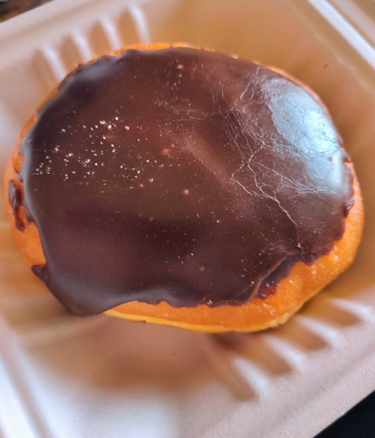 Chocolate-glazed donut on a paper plate